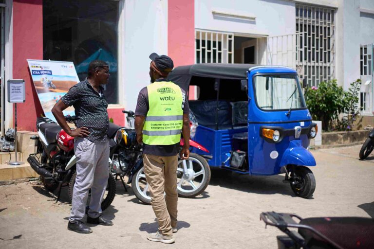 Watu Credit staff assisting customer near tuk-tuk