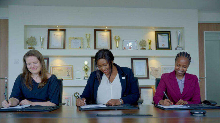 Shantnoo Saxsena, CEO of Anzens, and Betty Korir, CEO of Credit Bank PLC, shaking hands after signing a strategic partnership agreement for stablecoin infrastructure in Kenya.