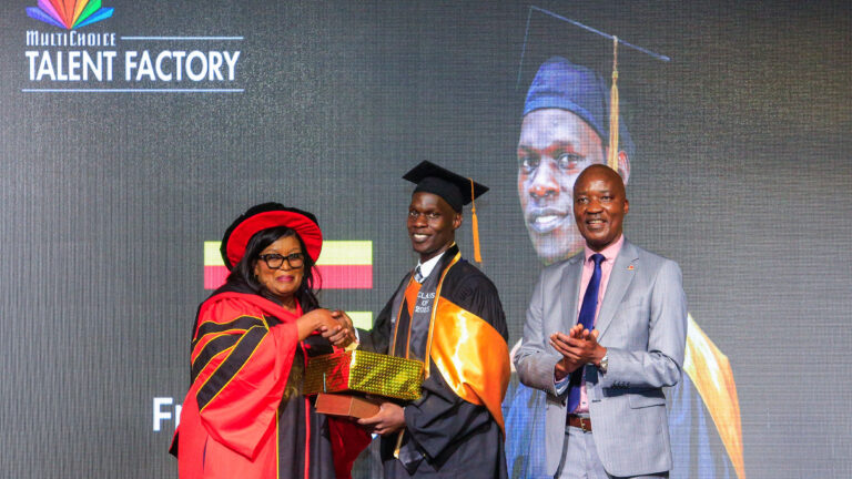 Victoria Goro presenting the Academy Director’s Award to Fredrick Mayiga as Timothy Owase looks on.