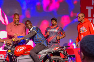 A moment of celebration as BetGr8 Chairman Jimal Ibrahim Hassan and Raymond Kitunga, Deputy Country Head at Spiro Kenya, present a Spiro electric bike to one of the fans during the 2026 World Cup opening experience at Uhuru Park