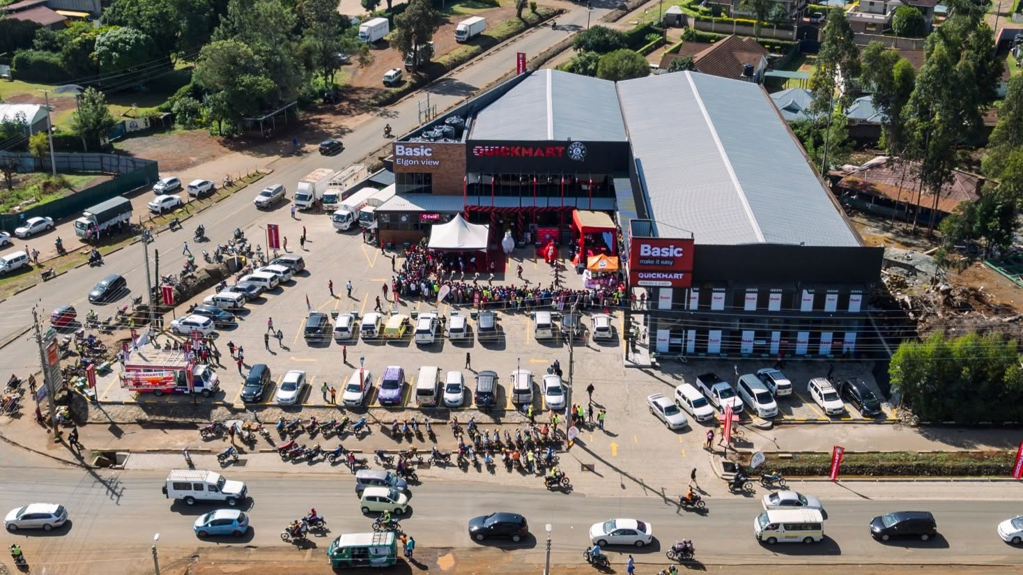 Aerial view of QuickMart's Basic Elgon View supermarket branch in Eldoret with crowds and vehicles at the launch event