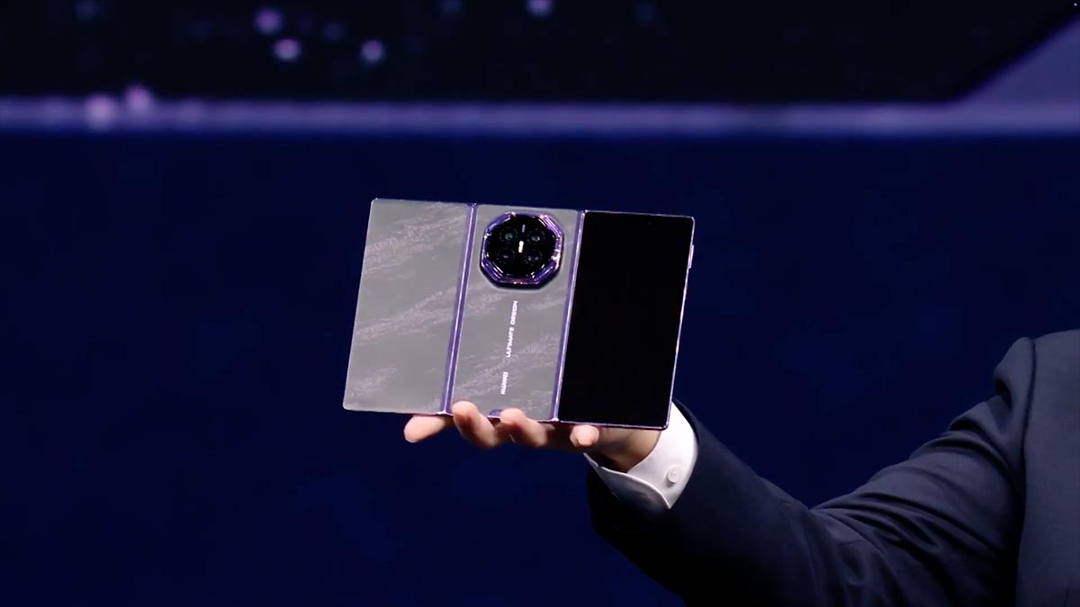 Huawei Mate XT2 Ultimate Design trifold phone held in a hand on stage
