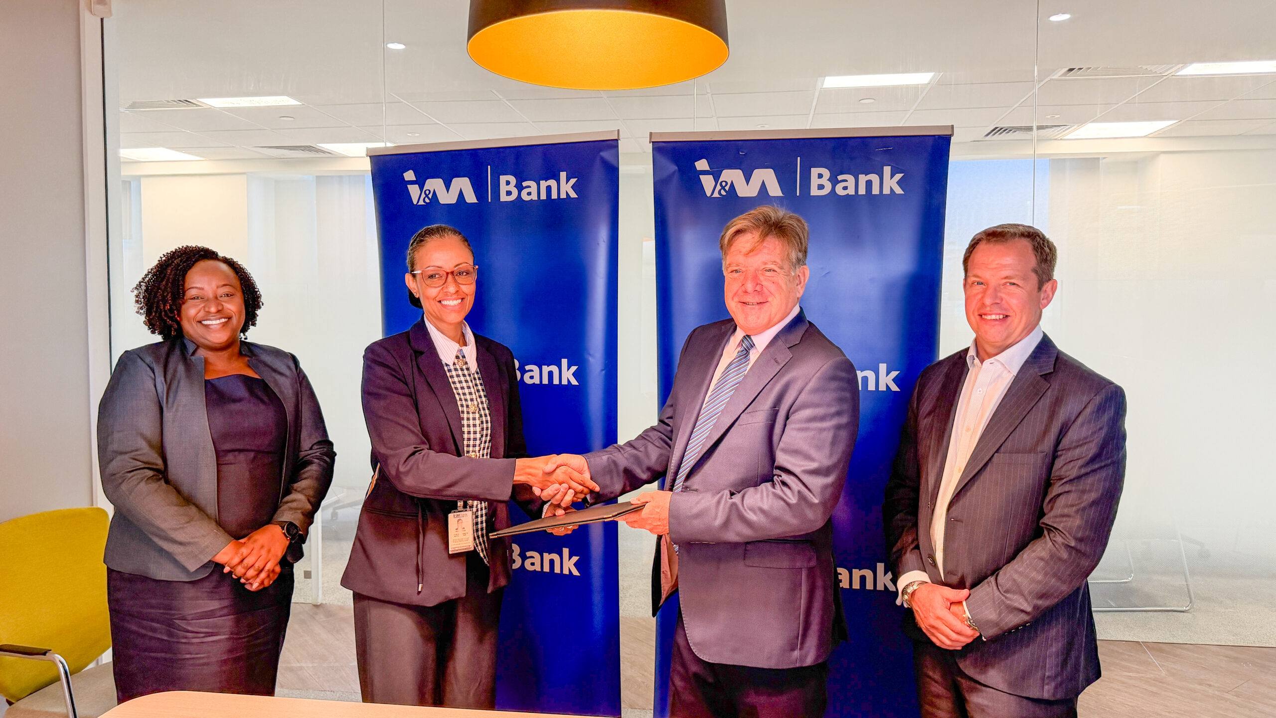I&M Bank and Surecomp executives shake hands at trade finance partnership signing