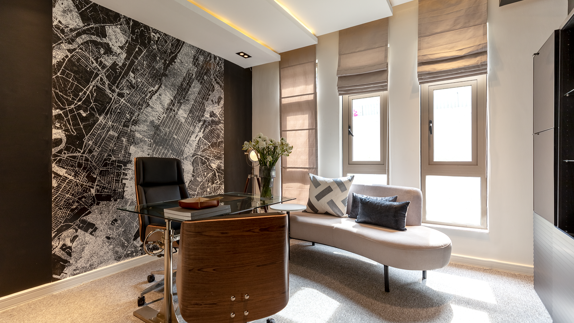 Study at Moments Villas with a glass desk, leather office chair and a large scale city map mural on a dark feature wall.