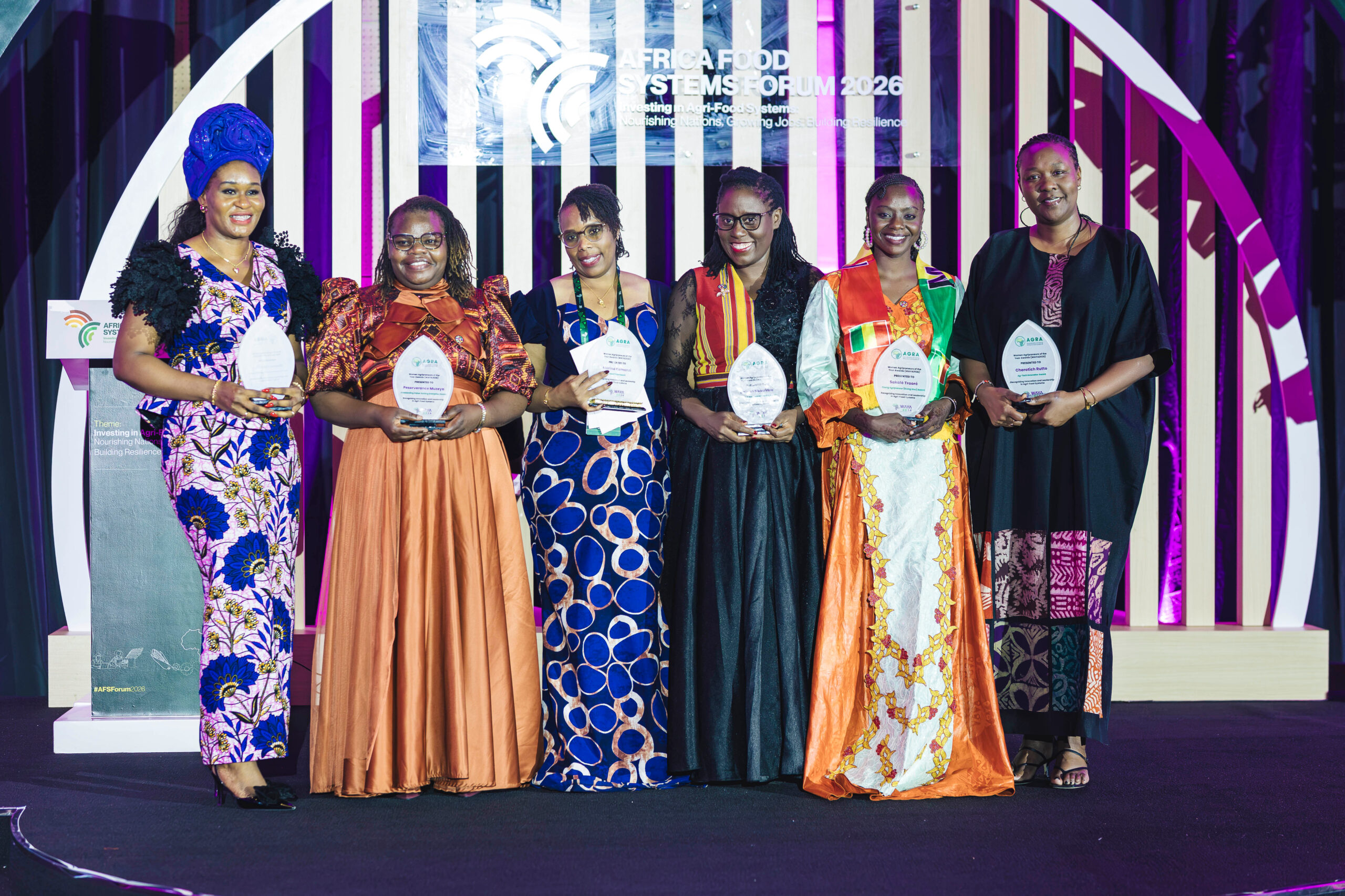 Six WAYA 2026 category winners stand together on stage holding their awards at the Africa Food Systems Forum in Kigali, including Ifeoma Mary Okonkwo, Marina Kamanzi, Perseverance Muzeya, Doreen Nsasiirwe, Sakalé Traoré and Cherotich Rutto.