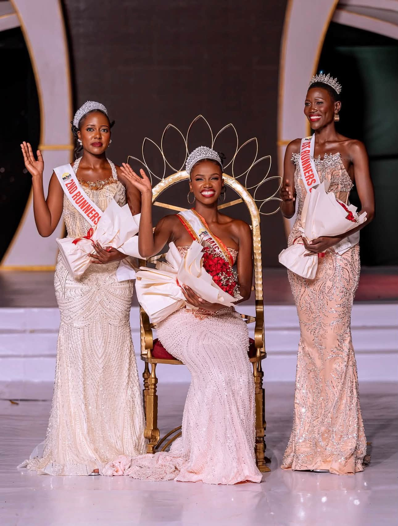 Miss Uganda 2026/27 Almorie Nagayi with first runner up Bridget Prudence Nakato and second runner up Lukia Balunywa, holding red roses.