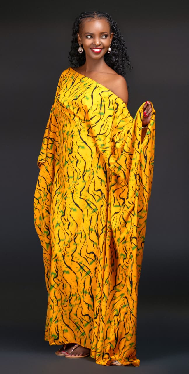 Shirleen Wangari, who plays Phoebe in Chamaa, smiles in a yellow kaftan with a black and green print.