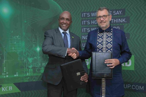 KCB Group Plc Chairman Andrew Wambari Kairu and Oliver Meisenberg, the Chief Executive Officer Trust Merchant Bank (TMB) exchanging documents on August 2, 2022 during a ceremony where KCB signed a definitive agreement to acquire a majority stake at TMB.