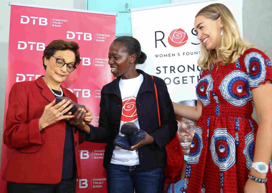 Diamond Trust Bank (DTB) Group CEO & Managing Director Nasim Devji reviews shoes from Hyline Kimuma Onsoti, a beneficiary of Rose Foundation as Allie Amoroso (R), Rose The Foundation's Executive Director looks on.