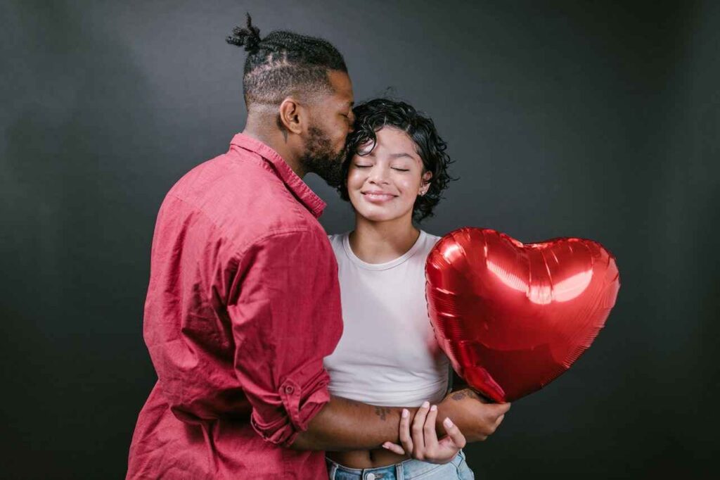 Couple Kissing While Holding a Red Heart Shaped Balloon one of the knowing who your partner is is .