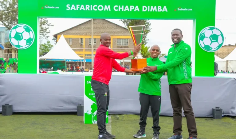 Safaricom CEO Peter Ndegwa (centre), Nairobi Senator Edwin Sifuna and Football Kenya Federation President Nick Mwendwa display Safaricom Chapa Dimba na Safaricom Season Four Trophy at Camp Toyoyo grounds in Nairobi.