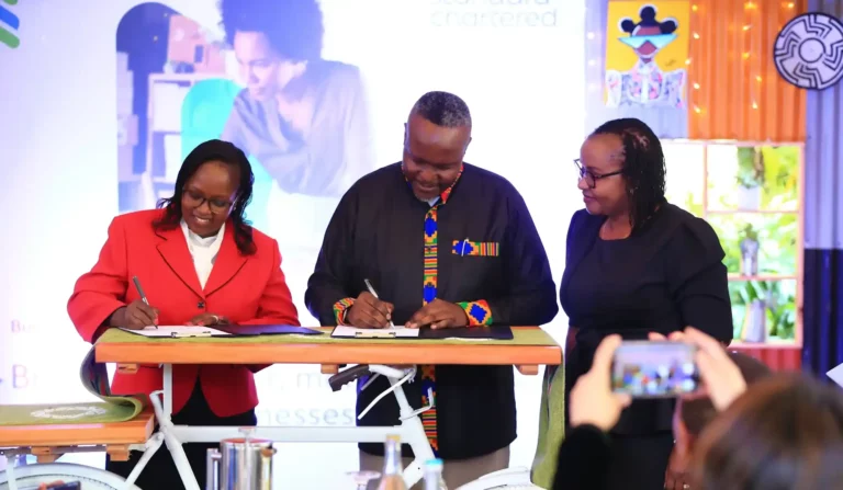 Esther Masese Waititu, Chief Financial Services Officer, Safaricom (left) and Kariuki Ngari, CEO , Standard Chartered (center) officially sign into partnership SC WIN (Standard Chartered Women International Network). Edith Chumba, Head CPBB, Standard Chartered, (far right) looks on.