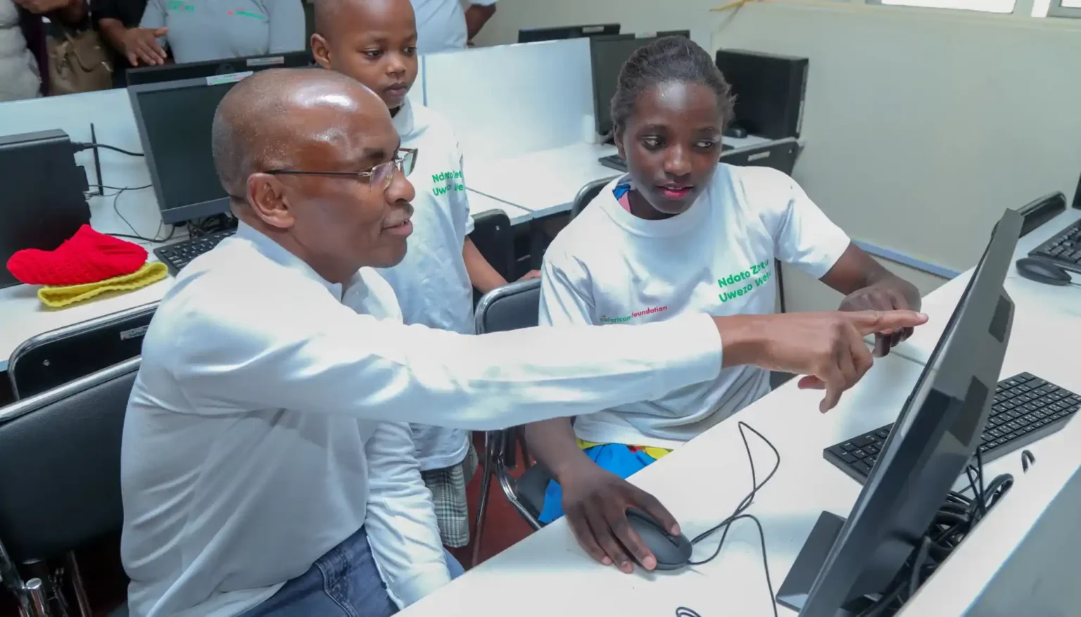 Mary Atika and Benita Kendi, students from Machakos School for the Deaf taking Safaricom PLC CEO Peter Ndegwa through the new computers they received during Safaricom Foundation’s Ndoto Zetu Phase 5 launch