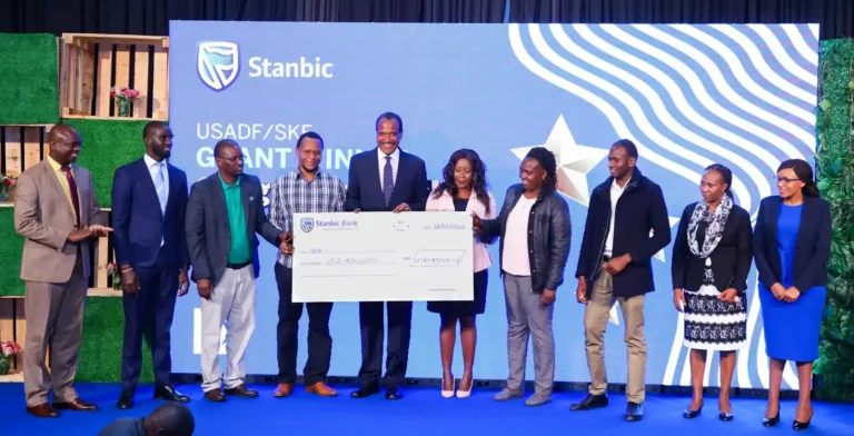 Kitili Mbathi, Chairman, Stanbic Bank Kenya, poses with 9 businesses that will receive a total USD 450,000 under the United States African Development Foundation (USADF) and Stanbic Kenya Foundation (SKF) Grant Fund.