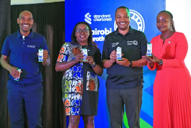 (left) Stella Ondimu, Head of Communication East Africa and West Africa - Tetra Pak, (middle) Peter Gitau, Local Organizing Committee - Chairman, Standard Chartered Bank Kenya and (right) Joyce Kibe, Head of Corporate affairs, Brand and Marketing, Standard Chartered Bank opening a recyclable water pack to be used during the Standard Chartered Nairobi Marathon later this month. Looking on (far left) is Master of Ceremony (MC) Lotan Salapei.