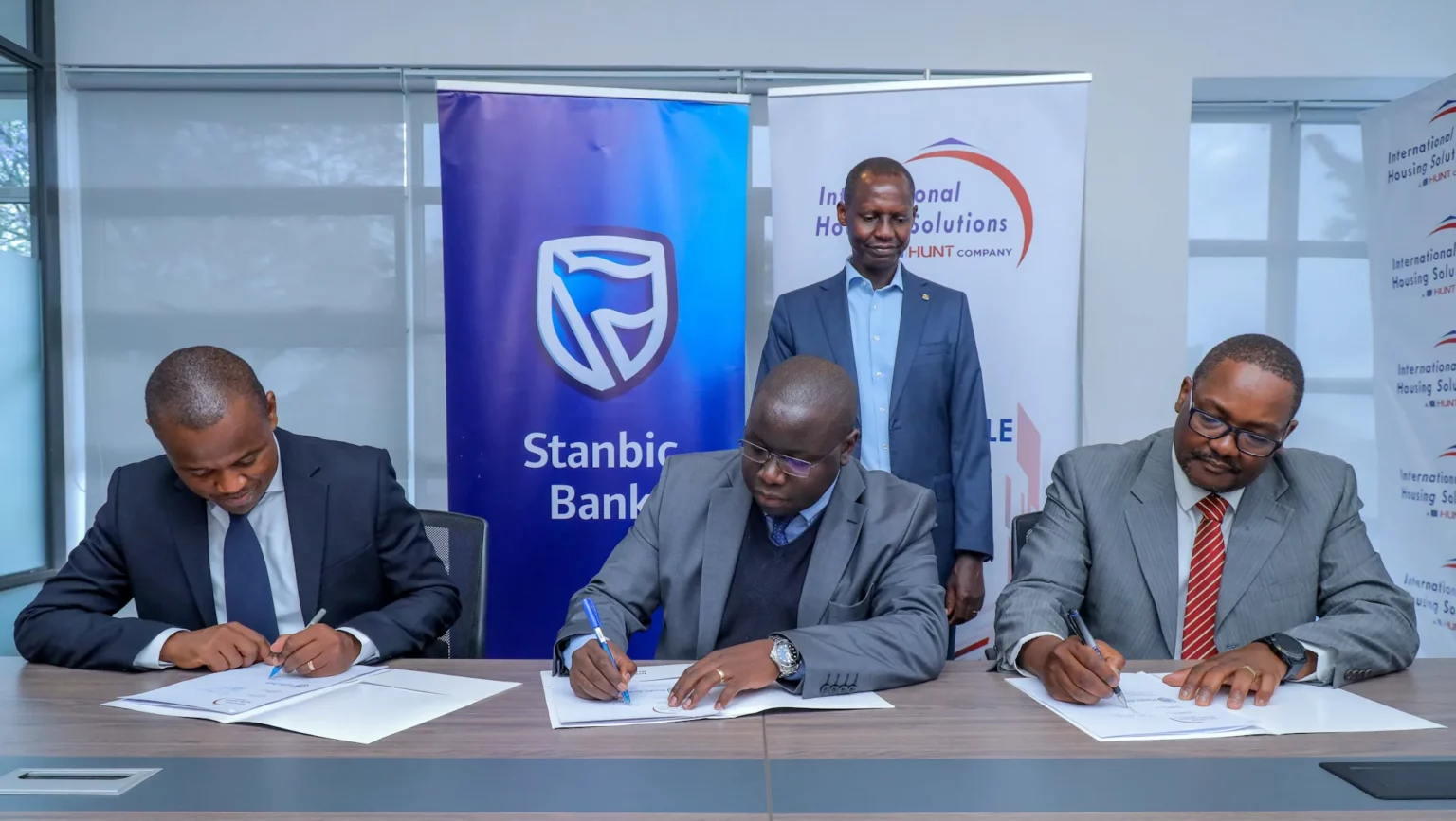 Stanbic Bank Kenya Head Personal and Private Banking, Abraham Ongenge (Far Left), International Housing Solutions Capital and Investor Relations Managing Director Peter Mayavi (Center), International Housing Solutions Investments and Asset Management Managing Director, Kioi Wambaa (Far Right) during the Memorandum of Understanding signing.Looking on is Kenya Mortgage Refinancing Company Head of Credit, Geoffrey Mwaura.