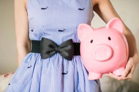 Girl Holding a Piggy Bank for saving. Fun activities, everyday examples, and age-appropriate tips to raise financially responsible children who understand saving, budgeting, and smart spending.