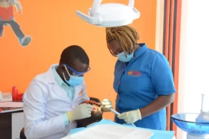 Equity Afia Langata Dental Technologist Patrick Onyango (left) and Dental Assistant Marion Chege (right) attend to a client. Equity Afia offers general dental services and restorative procedures such as fillings, root canals, and periodontal treatment