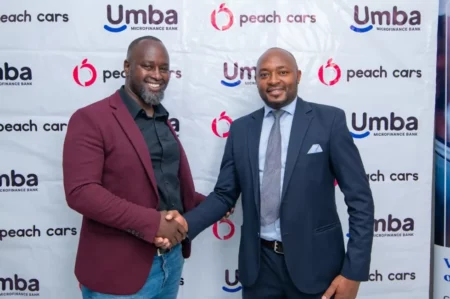 L-R, Martin Mugo, Branch Manager at Peach Cars shakes hands with Alvan Gesaka, Senior Credit Officer at Umba Microfinance Bank. Umba Microfinance Bank and Peach Cars have partnered to offer customers 24h car financing.