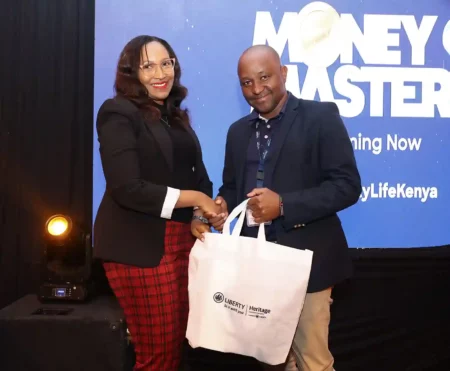 Heritage General Manager Health Business Antony Mwangi receives a gift hamper from Liberty General Manager Marketing and Communications Mercy Kabangi during the Money Master season 2 premiere.