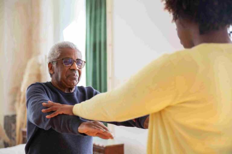 Global Palliative Care Research Is Growing—But Africa Needs a Stronger Voice Older African man receiving supportive care from a caregiver during rehabilitation therapy.