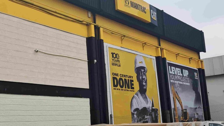 Mantrac Kenya Marks 100 Years of Caterpillar Dealership with Bold Vision for the Next Century Exterior of Mantrac Kenya building with Caterpillar branding, celebrating 100 years of dealership with promotional posters on construction and excavators.