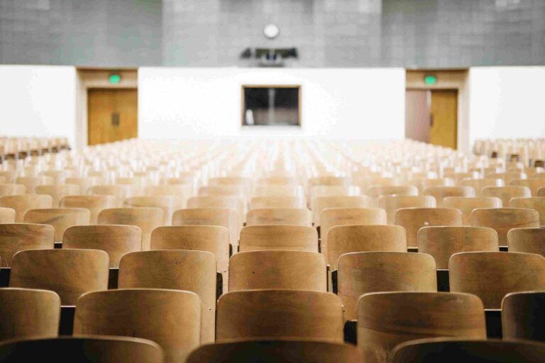 Bending AI to Africa’s needs: the key to transforming classrooms Empty lecture hall with tiered wooden seats facing a teaching area, symbolising traditional education settings in Africa.
