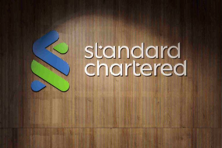 Standard Chartered logo displayed on a wooden wall at a corporate office.