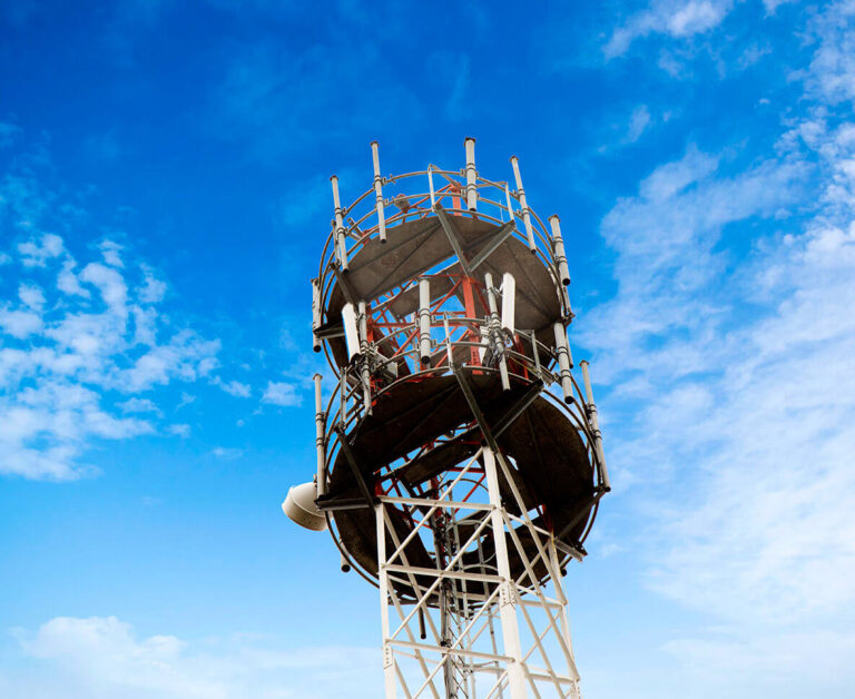 Telecommunications tower with antennas under blue sky, supporting mobile connectivity and digital services in Rwanda.