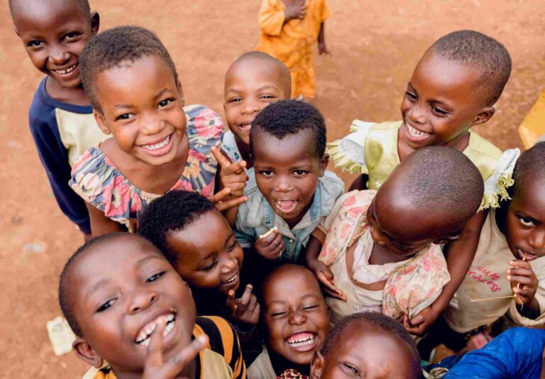 Smiling African children participating in a community oral health outreach program.