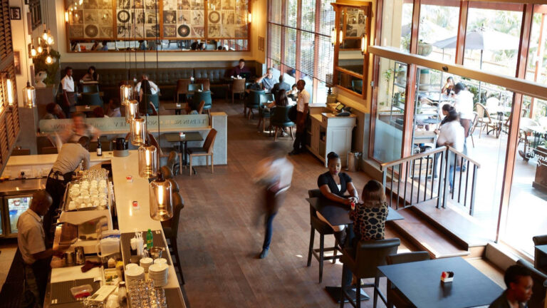 Kenya’s Restaurants Are Chasing Diners Where They Live Overhead view of Artcaffé's Westlands, Nairobi restaurant, with staff and diners at the bar, tables and terrace.