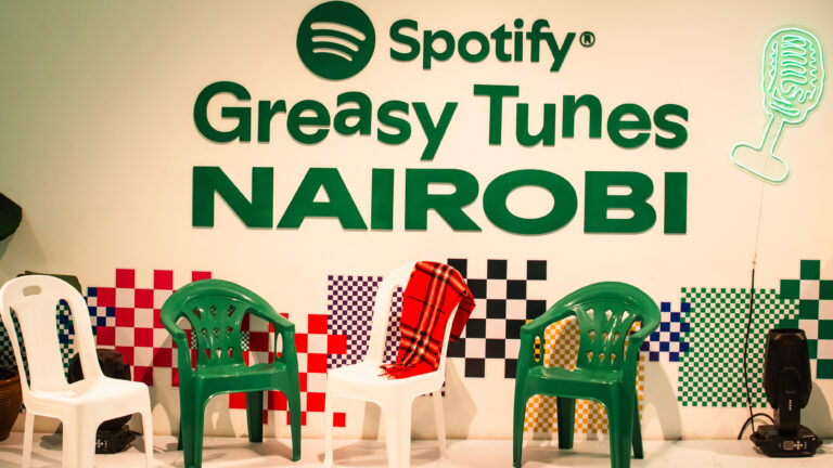Spotify Brings Greasy Tunes Café Kitchen to Nairobi Spotify Greasy Tunes Nairobi wall logo behind green and white plastic chairs with a checkered backdrop