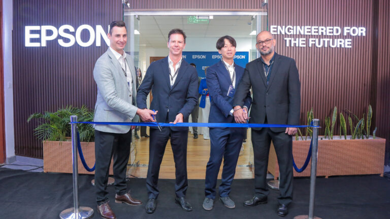 Epson executives cut a ribbon at the entrance to the expanded Nairobi office, with an Epson sign reading "Engineered for the Future" behind them.