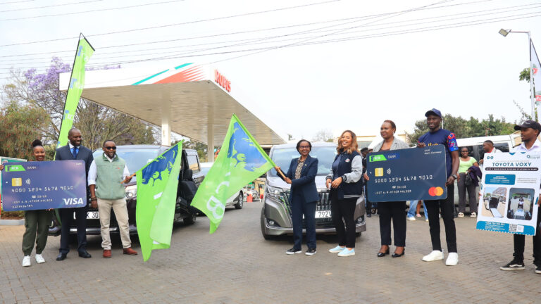 KCB, RUBiS Energy Kenya and KTB officials flag off the Kenya Beyond Sight team at a RUBiS station in Nairobi, holding oversized KCB debit and Mastercard cards beside a wheelchair accessible Toyota Voxy